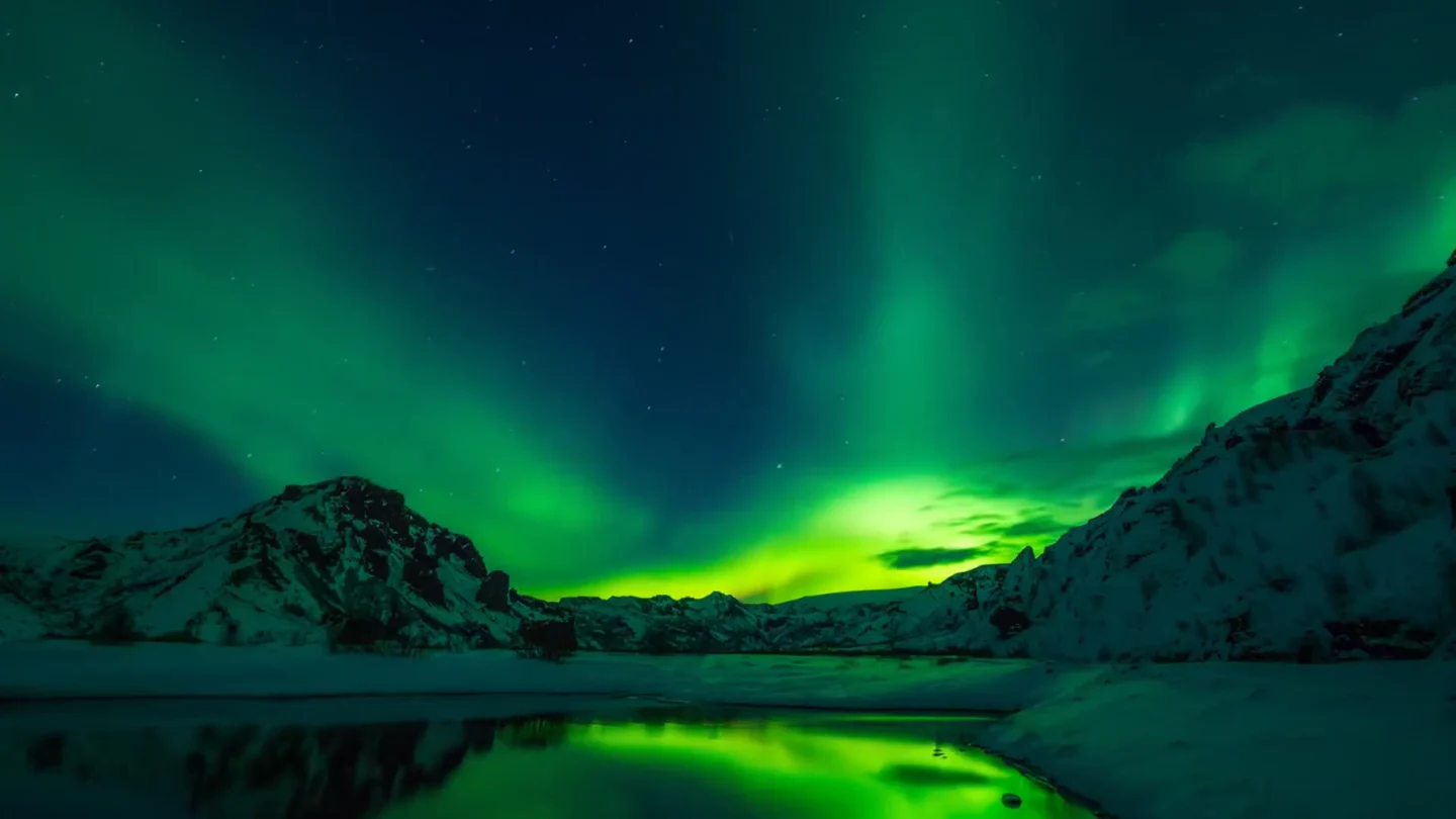 Green northern lights over snowy mountains, an included LivePaper wallpaper