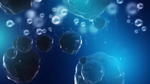 Bubbles rising slowly through lit water.