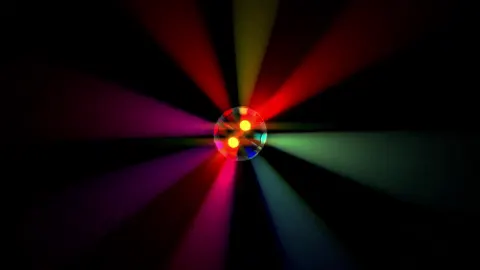 Club lighting sweeping colour across an empty floor.