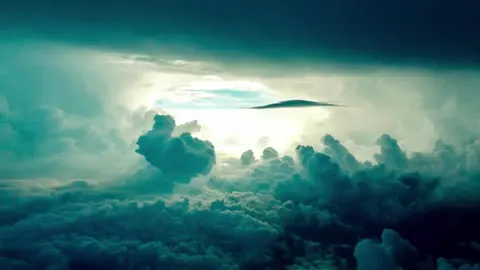A blue sky with clouds drifting quietly across it.