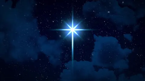 A Christmas star turning slowly above the tree.