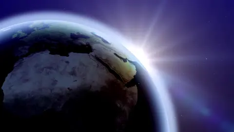 Earth turning with the sunrise creeping across it.